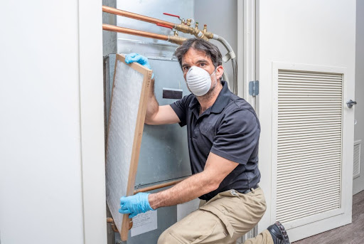 A man installing a new HVAC air filter.